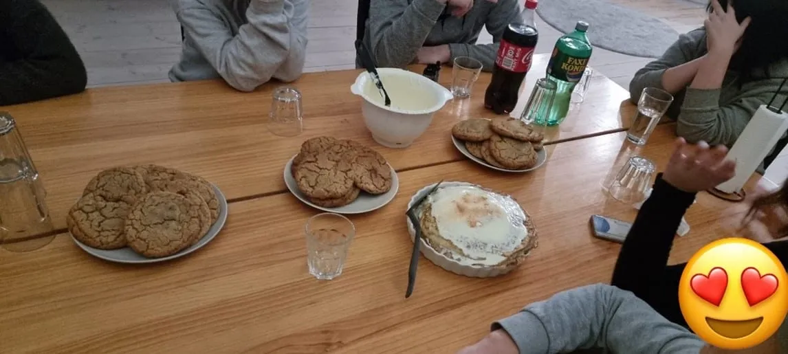 Eftermiddagssamling om bordet med frugt, kiks og kage